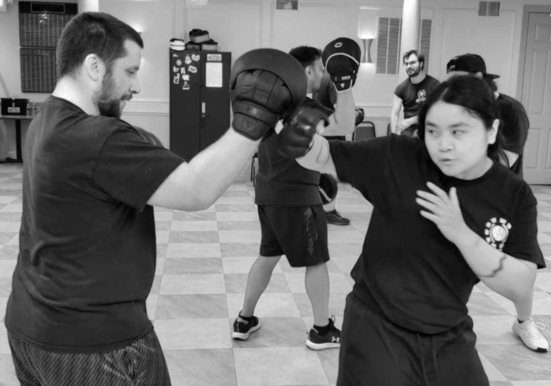 Student throwing a punch into focus mitts