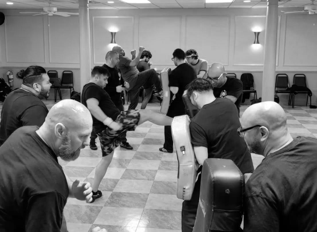 Students drilling kicks on kick shields